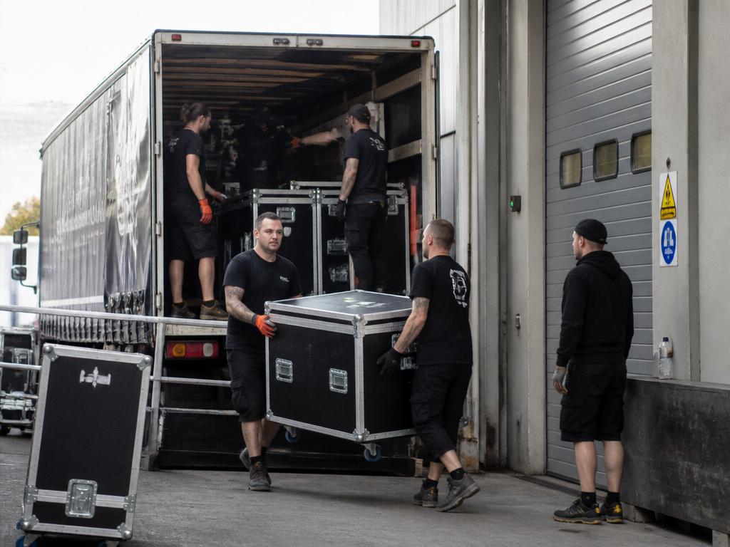 Workers loading and unloading equipment cases at an event venue
